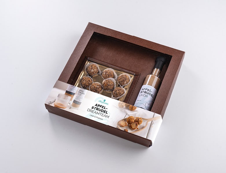 braune Geschenkpackung mit Fenster, man sieht Pralinen und den Likör