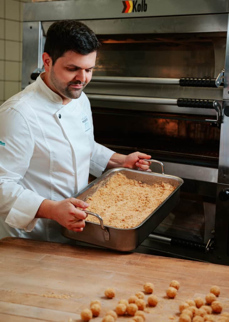 Mathias Baumgartner mit einer Pfanne Butterbrösel in der Backstube